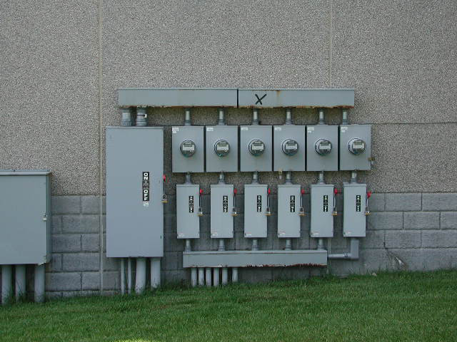 photo of several meters, flu and gutter attached to the exterior of a building