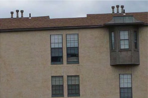 photo of the side of a residential building with a bay window