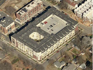Aerial photo of a parking garage fully lined with apartment buildings on all sides