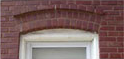Close-up of a segmented arch made of masonry above a window opening