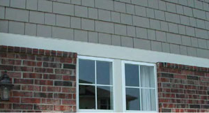 side of a residential building with brick siding interrupted by a window