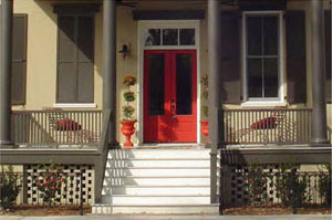 photo of a residential building front door with a transom window above the door and columns supporting a roof